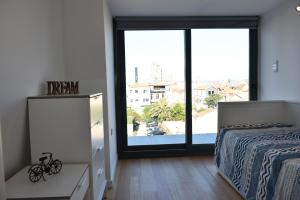 a bedroom with a bed and a view of a city at Sunny Penthouse whith balcony 9min walk main station in Porto