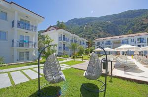 a view of a resort with chairs and buildings at Belcekum Beach Hotel in Oludeniz