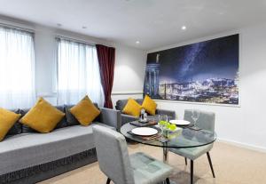uma sala de estar com um sofá e uma mesa de vidro em Stewart by Heeton Concept - Aparthotel Edinburgh em Edinburgo