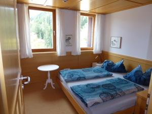 a bedroom with a bed and a window and a table at Widderstein Apartments in Schröcken