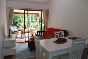 a white table and chairs in a room with a patio at Cashew Nut Grove Chalets in Port Glaud