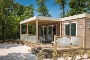a tiny house with a wrap around porch at Mobile Homes Premium Relax Park Umag by Camp4You in Umag