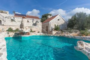 a pool of blue water in front of a building at Stonehouse Marina in Vrsine