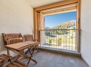 ein Tisch und ein Stuhl in einem Raum mit einem großen Fenster in der Unterkunft Apartmani El Tarik in Bjelašnica