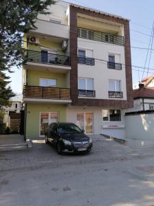 a black car parked in front of a building at Hostel Denica in Skopje