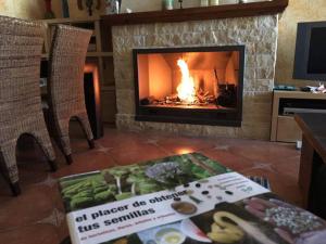 - un salon avec une cheminée et une table avec un livre dans l'établissement La Casa Viva. Alojamiento responsable y sostenible., à Vélez-Blanco