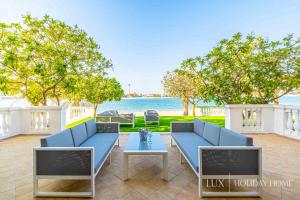 a patio with two blue couches and a table at LUX - The Dubai Paradise Palace in Dubai