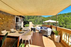 een patio met een tafel en stoelen en een parasol bij Villa Magdalena Calvia in Calvia Town