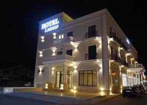 a white building with a sign on it at night at Hotel Lazaro in Podgorica
