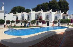 a large white building with a swimming pool in front of it at PINOS 22 MENYBER in Nerja