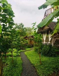 a path leading to a house in a garden at บ้านไร่ชายทุ่ง in Kanchanaburi