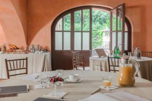 a dining room with tables and chairs and windows at QC Termeroma Spa and Resort in Fiumicino