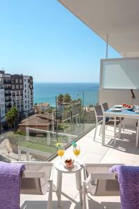 a balcony with tables and chairs and a view of the ocean at Calpe Beach in Calpe