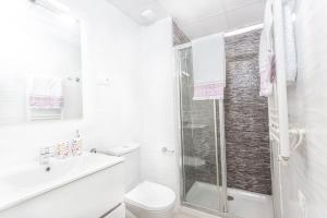 a white bathroom with a shower and a toilet at Calpe Beach in Calpe
