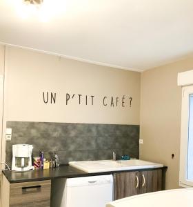 Grand appartement idéalement situé 7 places في Desvres: مطبخ مع حوض وإشارة على الحائط