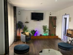 uma sala de estar com televisão e bancos em Fonte Luminosa em Lisboa