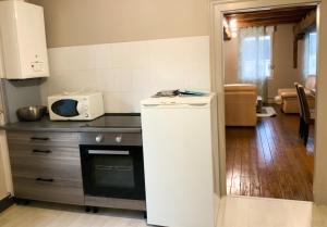Grand appartement idéalement situé 7 places في Desvres: مطبخ مع ثلاجة وميكروويف