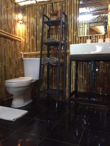 La salle de bains est pourvue de toilettes et d'un lavabo. dans l'établissement บ้านไร่ชายทุ่ง, à Kanchanaburi