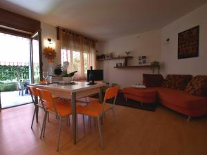 sala de estar con mesa, sillas y sofá en Belvilla by OYO Cherry House, en Mergozzo