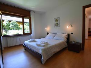 1 dormitorio con 1 cama con 2 toallas en Belvilla by OYO Cherry House, en Mergozzo