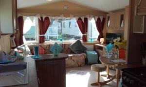 kuchnia i salon z kanapą i stołem w obiekcie Sunspot Brixham w mieście Brixham