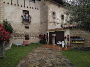 a stone house with a patio in front of it at Casa Rural El Granero in Treviana
