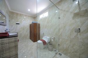 a bathroom with a toilet and a glass shower at Gili Meno Mojo Beach Resort in Gili Meno
