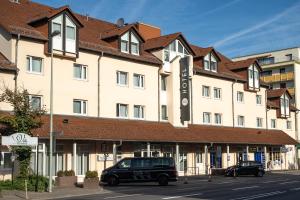 una furgoneta estacionada frente a un edificio en Taste Smart Hotel Lampertheim en Lampertheim