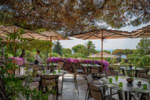 a restaurant with tables and chairs under umbrellas at Grand-Hôtel du Cap-Ferrat, A Four Seasons Hotel in Saint-Jean-Cap-Ferrat