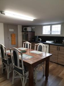 a kitchen with a wooden table with chairs around it at T1 Dans Maison Au Calme in Réalmont