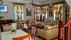 a living room with a couch and tables and chairs at Hotel Guri in Elbasan