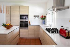a kitchen with white counters and a red appliance at Quinta Turki Malika in Óbidos