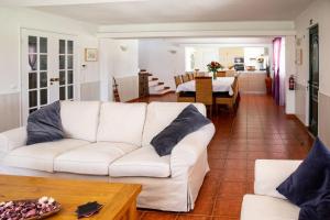 ein Wohnzimmer mit einer weißen Couch und einem Tisch in der Unterkunft Quinta Turki Malika in Óbidos
