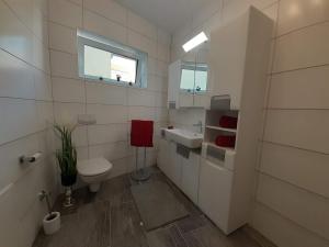 a white bathroom with a toilet and a sink at Haus Renè in Villach +28 photos