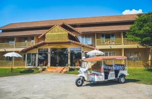 a golf cart parked in front of a building at RoomQuest Golden Triangle Premium Collection in Chiang Saen