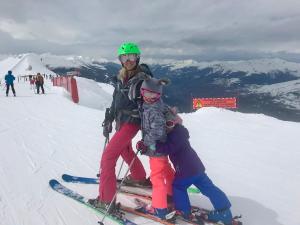 a woman and a child on skis in the snow at Arc 1950 Apartment - Sources de Marie, Mountain View in Arc 1950