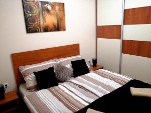 a bedroom with a large bed with two pillows at Olga Apartman in Szeged