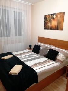 um quarto com 2 camas com lençóis brancos e pretos em Olga Apartman em Szeged