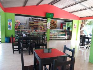 un restaurante con mesas y sillas y una pared roja en Hotel Los Mangos, en San Luis