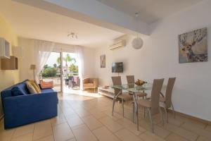 a living room with a blue couch and a table at Narcissos 'Nissi Beach' apartment C3 in Ayia Napa