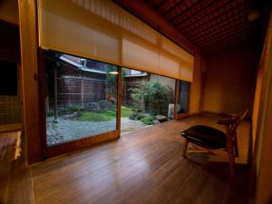 an empty room with a large window and a chair at SUKIYA-zukuri Suehiro in Hida