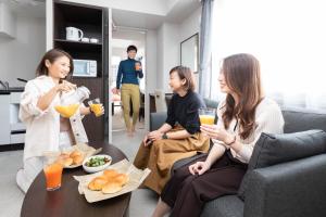 a group of women sitting in a living room with drinks at Hotel Classe Stay Sapporo in Sapporo