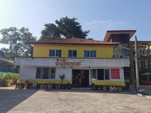 un edificio blanco y amarillo con un restaurante en Nam Pueng Place 1, en Chiang Saen