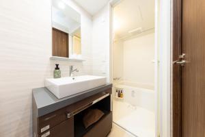 札幌市にあるホテルクラッセステイ札幌のバスルーム(白い洗面台、鏡付)