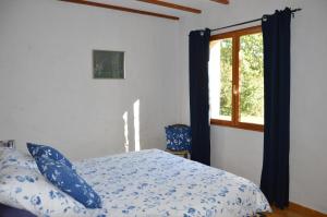 1 dormitorio con cama y ventana en Le gîte de Valérie côté jardin, en Die