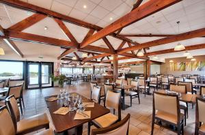 Village Club Kerlannic في أرزون: غرفة طعام مع طاولات وكراسي خشبية