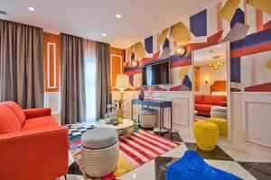 a living room with colorful furniture and a tv at HOLM Boutique & SPA - IK Collection in St. Julianʼs