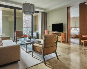 a living room with a couch and a table and a television at Four Seasons Hotel Casablanca in Casablanca