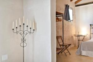 una habitación con un candelabro con cuatro velas en la pared en Casina Solatia, en Nardò