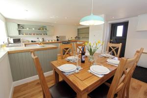 a kitchen and dining room with a wooden table at Monkstadt No 7 - Flora's Secret in Portree